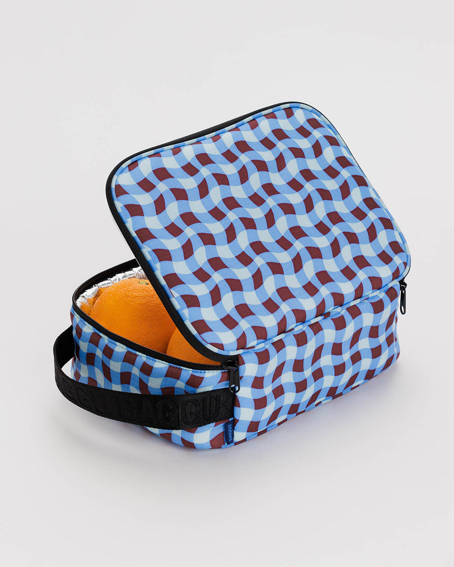 opened blue and brown wavy gingham print lunch box filled with oranges
