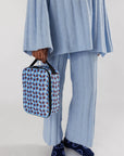 model holding blue and brown wavy gingham print lunch box