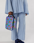 model holding periwinkle lunch box with pixelated wild strawberry print