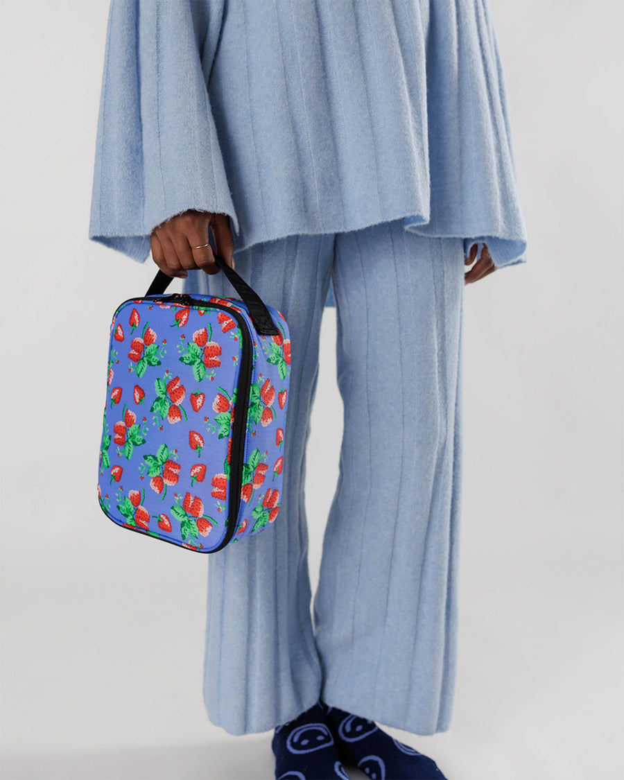 model holding periwinkle lunch box with pixelated wild strawberry print