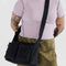 model wearing black medium cargo crossbody bag