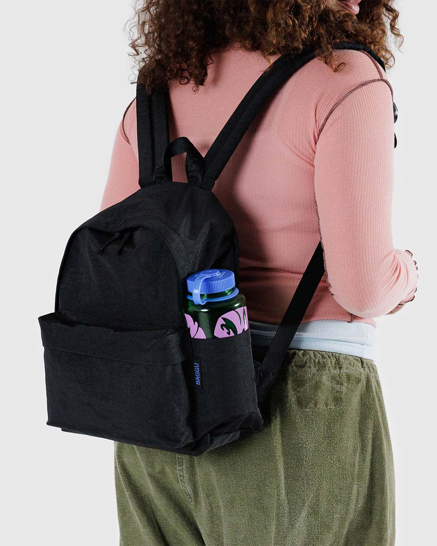 model wearing black medium nylon backpack