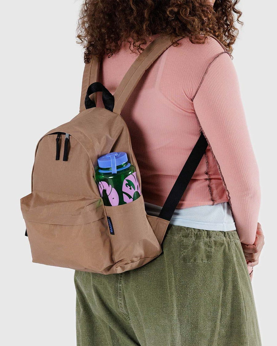 model wearing light taupe brown medium nylon backpack