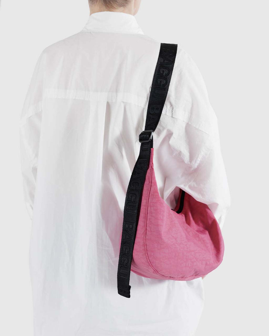 model wearing light pink medium nylon crescent bag