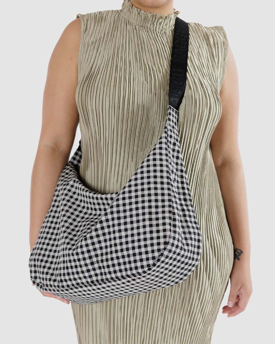 model wearing black and white gingham medium crescent bag