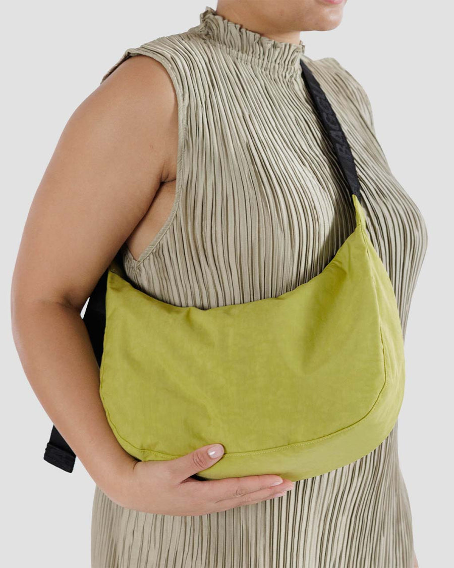 model wearing lime green medium nylon crescent bag