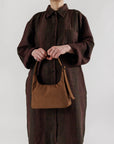 model holding brown mini nylon shoulder bag