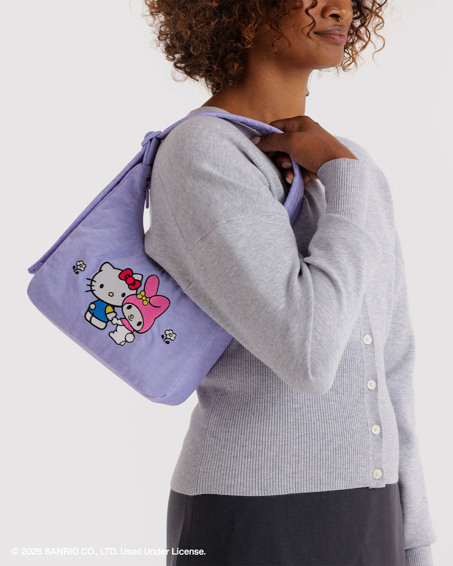 model carrying lavender mini nylon shoulder bag with embroidered hello kitty and my melody holding hands