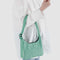 model holding green and white gingham nylon shoulder bag