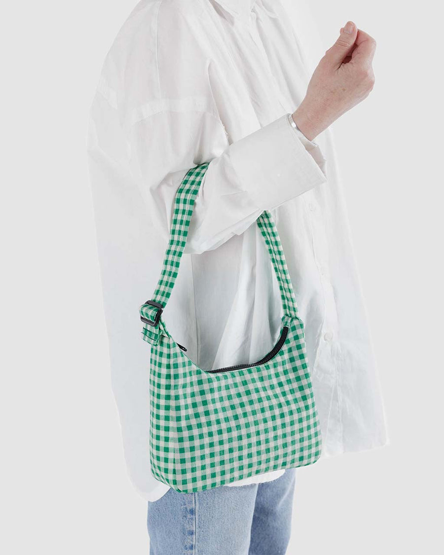 model holding green and white gingham nylon shoulder bag
