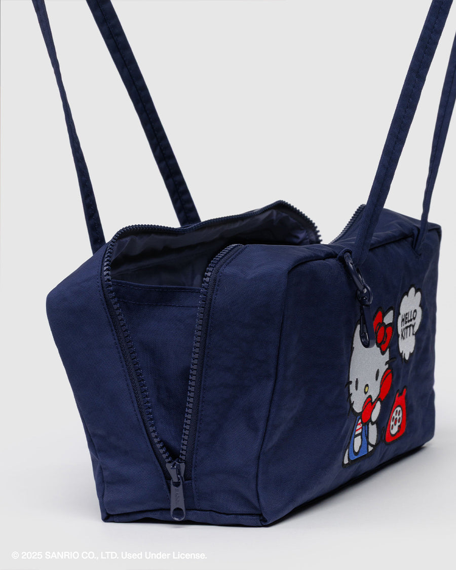 side view of navy nylon bowler bag with embroidered hello kitty talking on a red phone