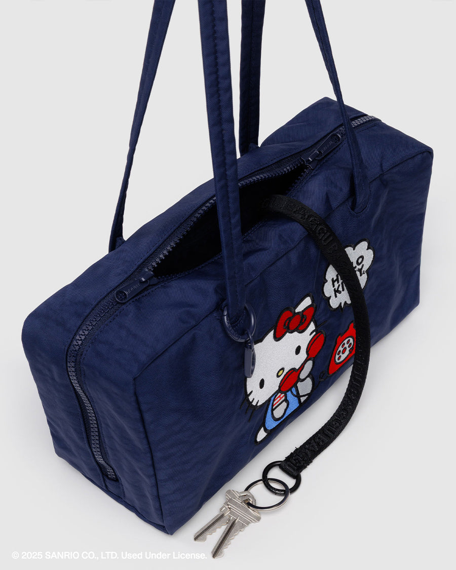 black interior key leash of navy nylon bowler bag with embroidered hello kitty talking on a red phone