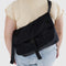 model wearing black nylon messenger bag with black front buckle