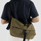 model wearing seaweed nylon messenger bag with black front buckle