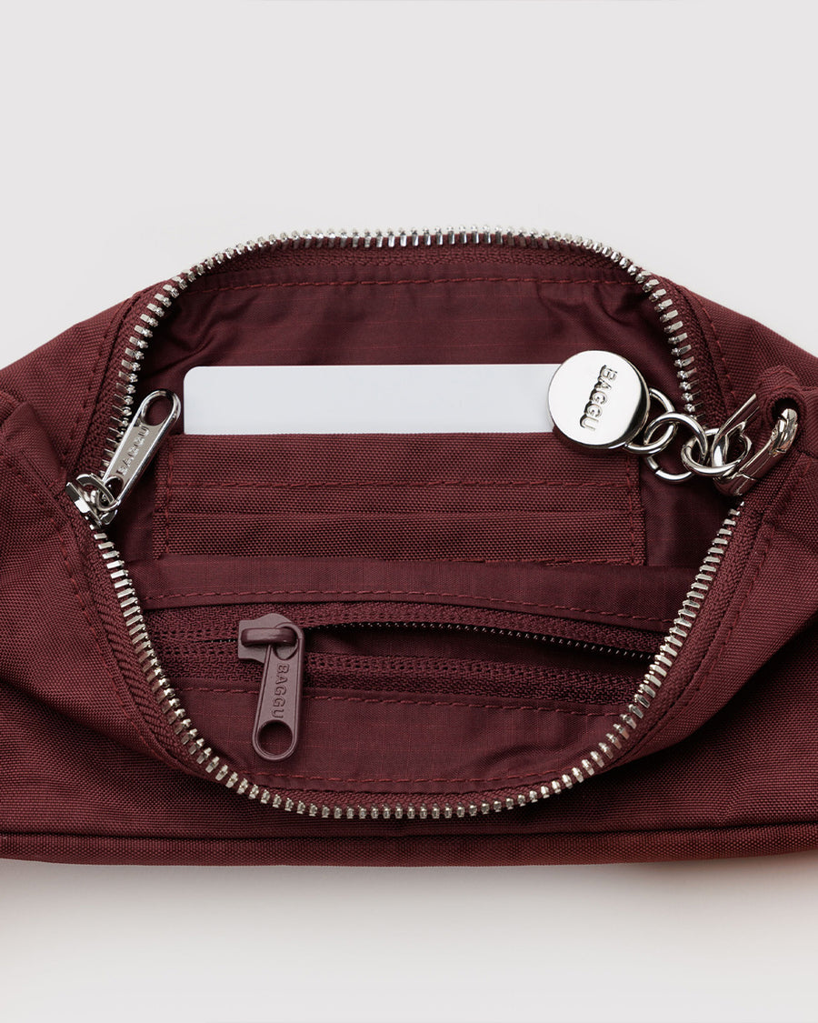 interior of nylon mahogany pochette bag with smiley charm and adjustable shoulder strap