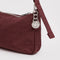 up close of nylon mahogany pochette bag with smiley charm and adjustable shoulder strap