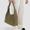model holding dark green nylon shoulder bag