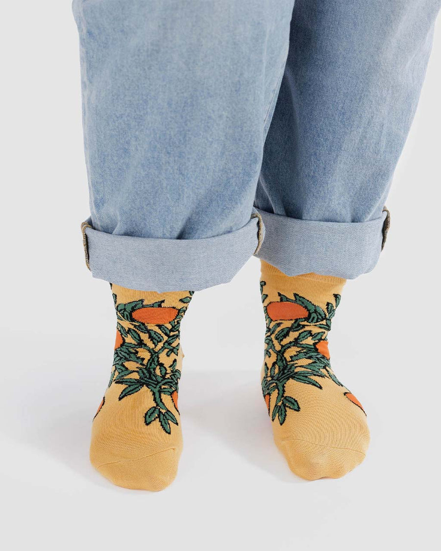 model wearing coral crew socks with orange tree design