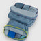 set of two digital denim packing cubes with neon zippers filled with clothing