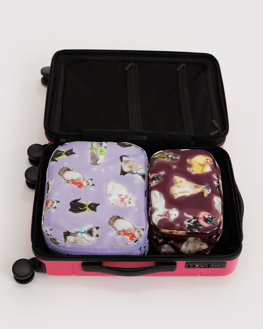 set of two packing cubes: small maroon fancy dogs and large lilac fancy cats in a suitcase