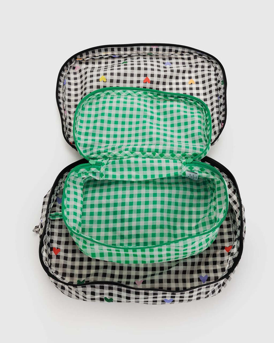 insides of set of 2 packing cubes: green gingham and black and white gingham with colorful hearts