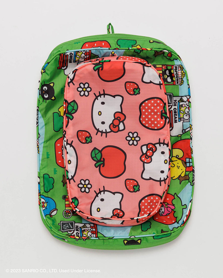 un-packed set of two packing cubes: small pink hello kitty apple and medium green hello kitty and friends scene