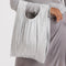 model carrying silver pleated metallic baggu bag with drawstring