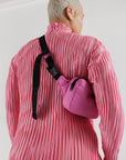 model wearing extra pink puffy fanny pack with black strap