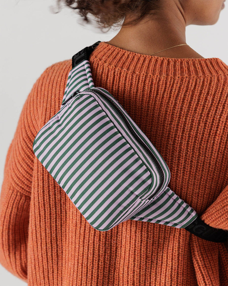 model wearing lilac and green vertical stripe puffy fanny pack