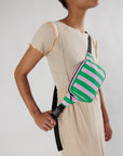 model wearing pink and green vertical stripe puffy fanny pack across their chest