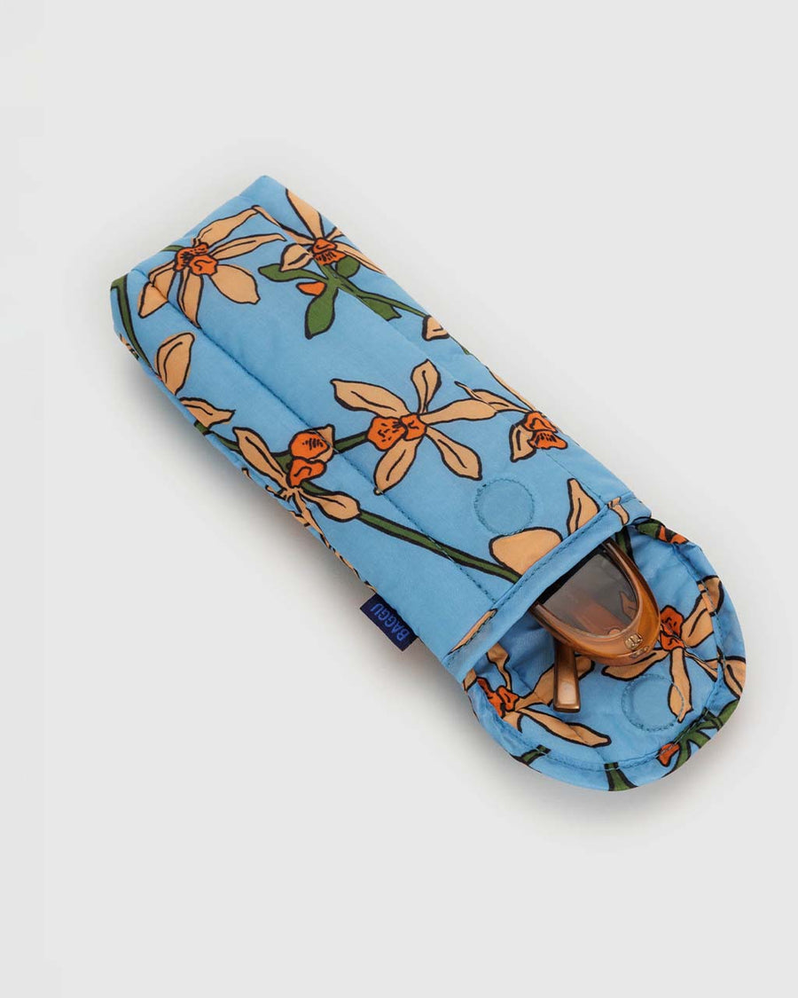 opened blue puffy glasses sleeve with golden orchid print with sunglasses inside