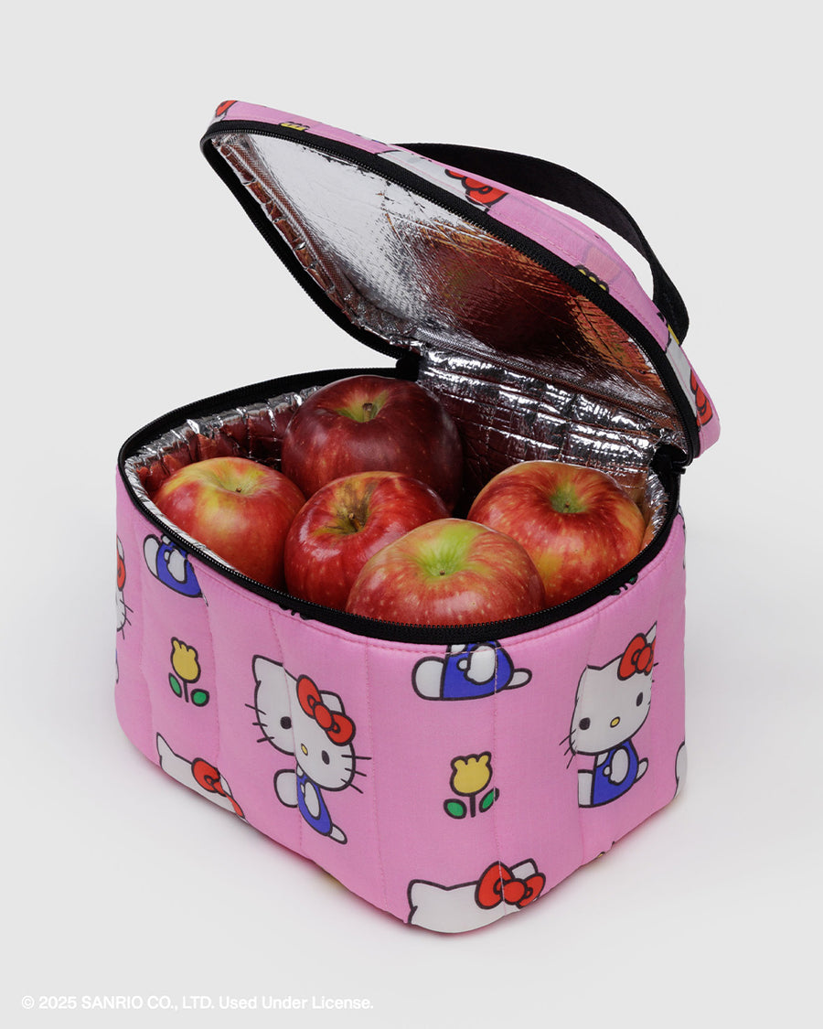 light pink puffy lunch bag with hello kitty and yellow tulip print and black trim and handle with apples inside