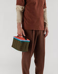 model holding puffy lunch bag with brown, green, light blue and orange color blocking