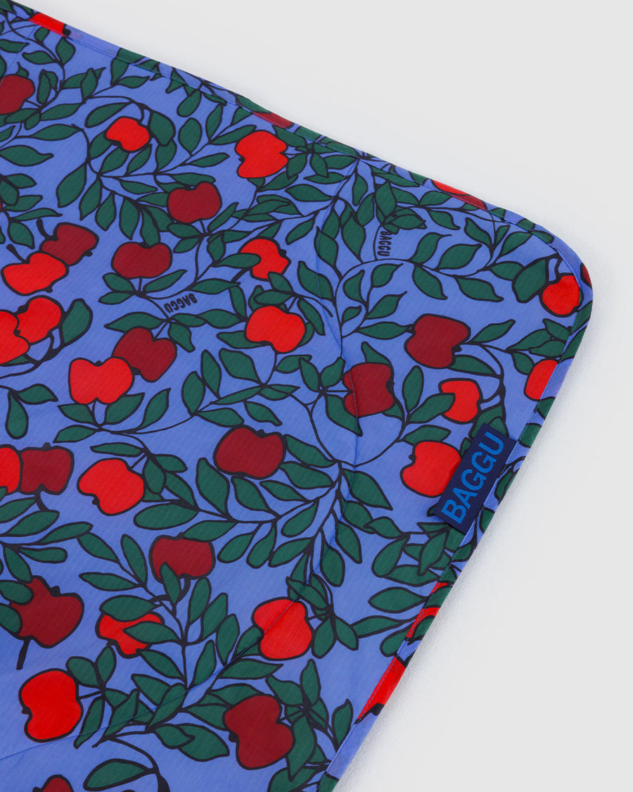 blue puffy picnic blanket with apple tree print
