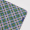 flattened pink, green, and blue plaid puffy picnic blanket with pale yellow star print