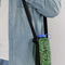 model wearing realistic grass puffy water bottle sling