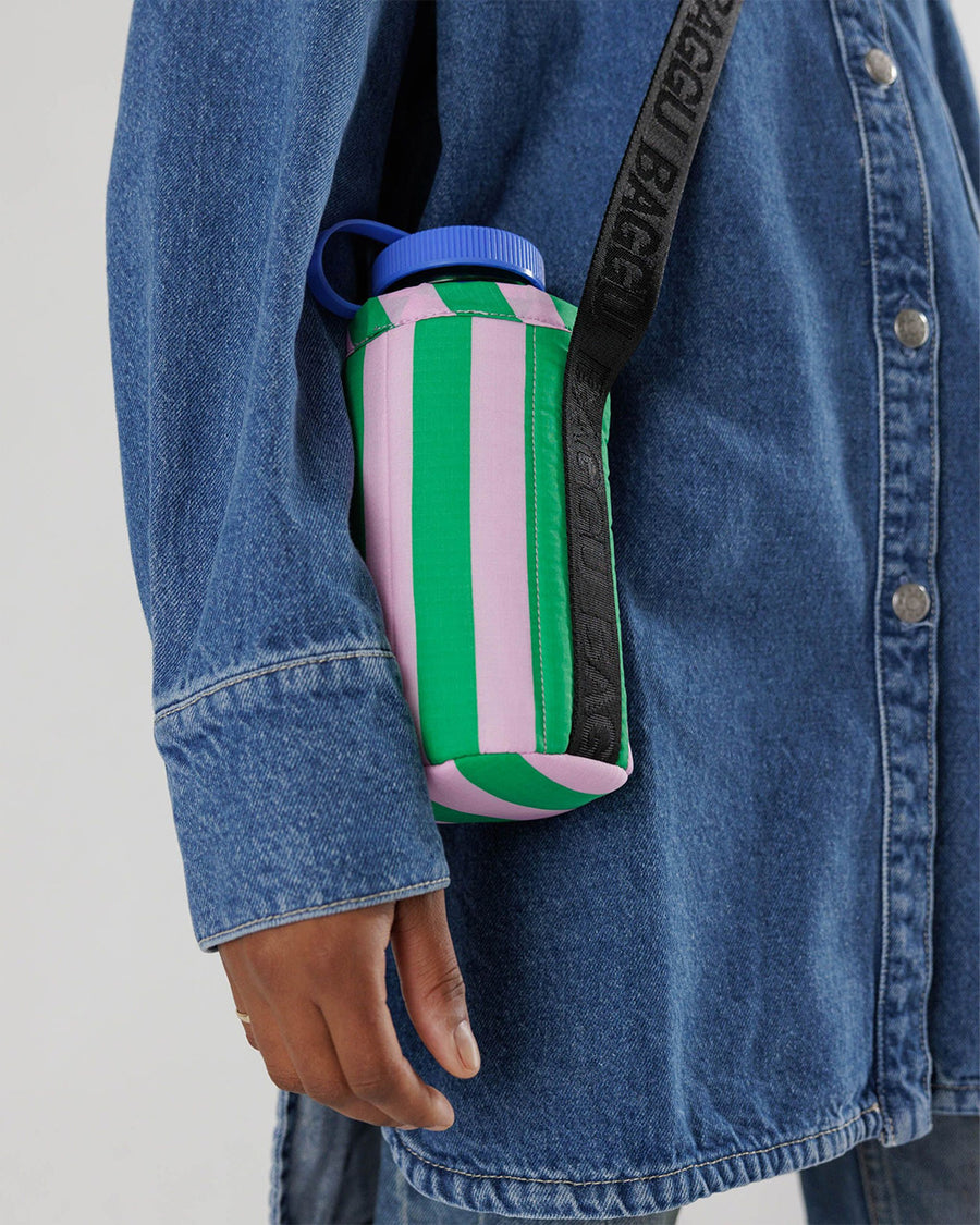 up close of model wearing puffy water bottle sling with pink and green vertical stripes