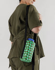 model wearing green and brown wavy gingham puffy water bottle sling
