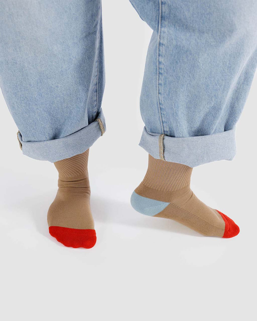 model wearing beige ribbed socks with yellow, blue and red accents