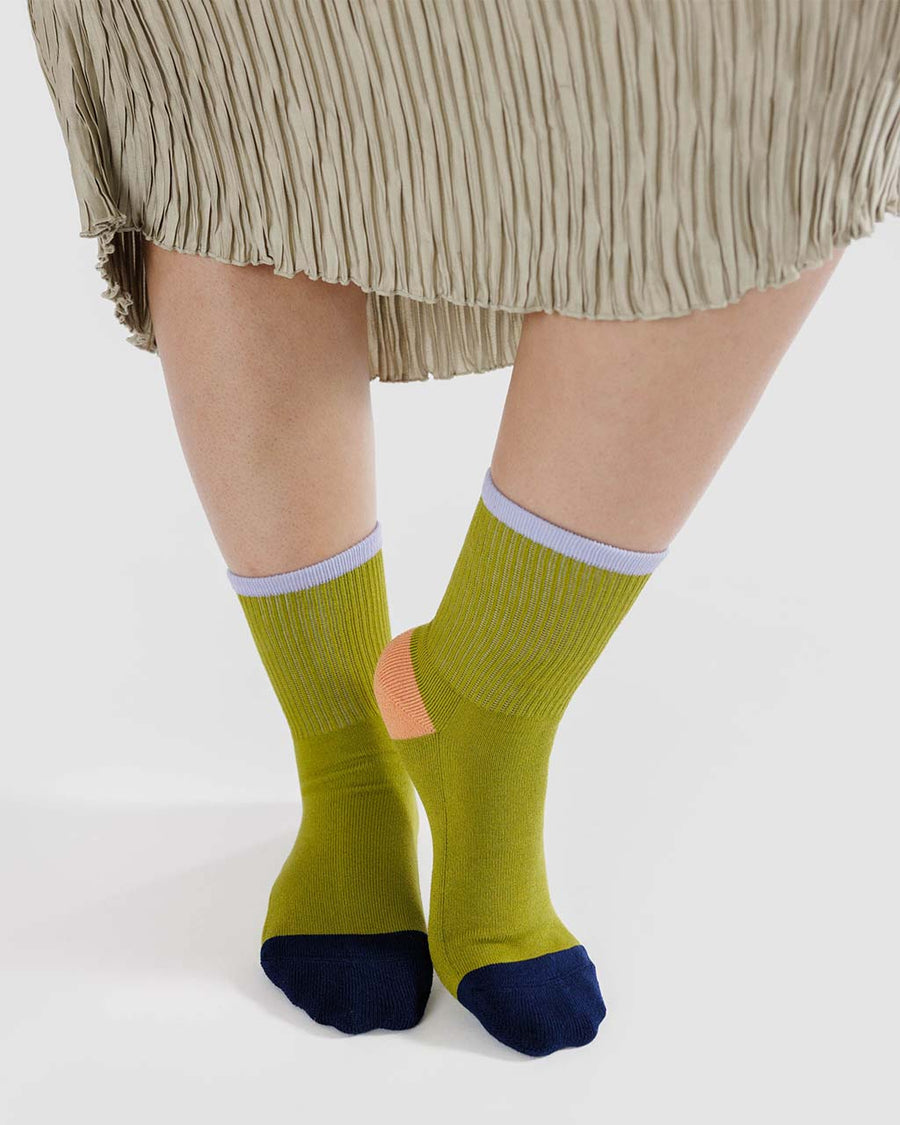 model wearing lime green crew socks with lilac, coral and dark blue accents