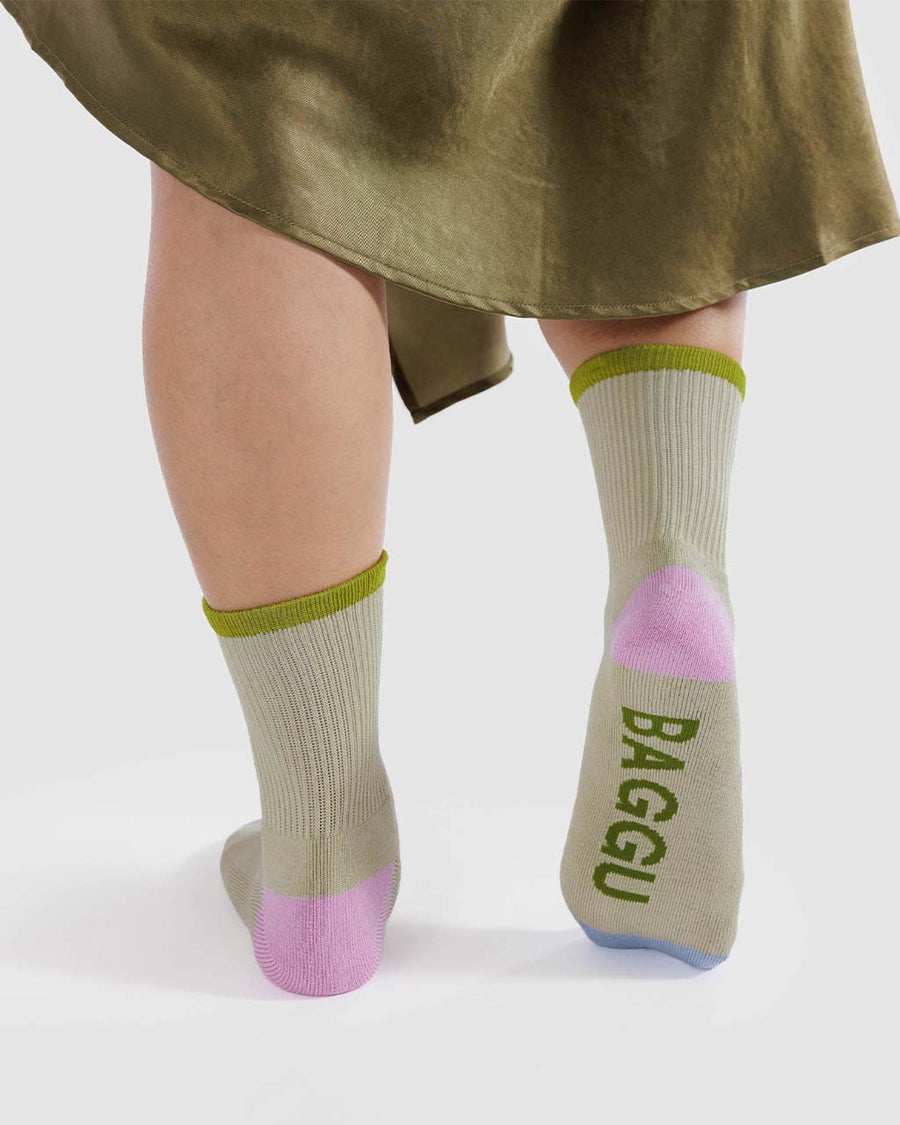 model wearing stone ribbed socks with lime green, bright pink and light blue accents