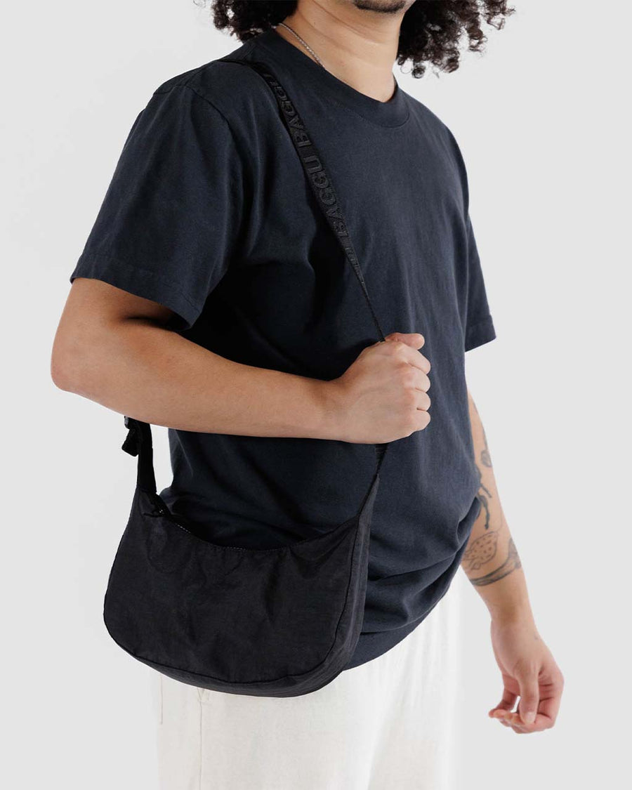 model wearing black small nylon crescent bag