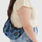 model carrying digital denim small crescent baggu with colorful bird and floral print