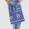model holding blue standard baggu bag with checkered tile print with cherry design