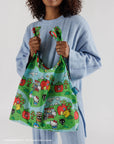 model holding standard baggu with hello kitty and friends village scene