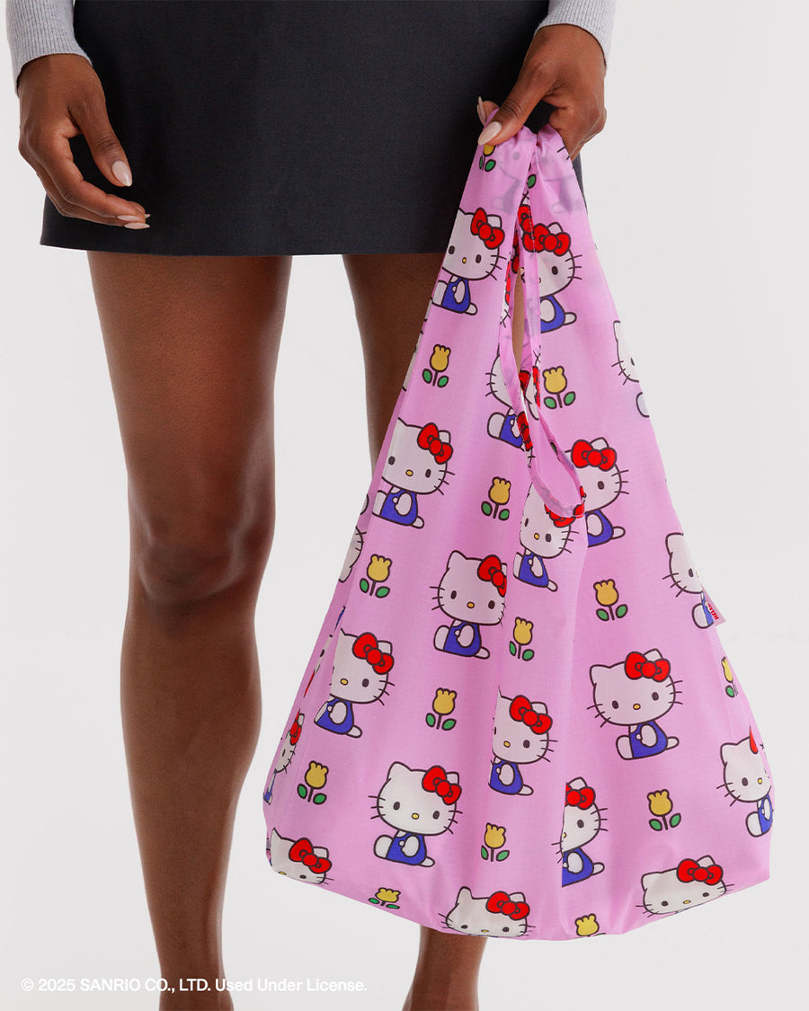 model carrying pink standard baggu with hello kitty and yellow tulip print