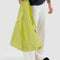 model holding bright yellow green standard baggu