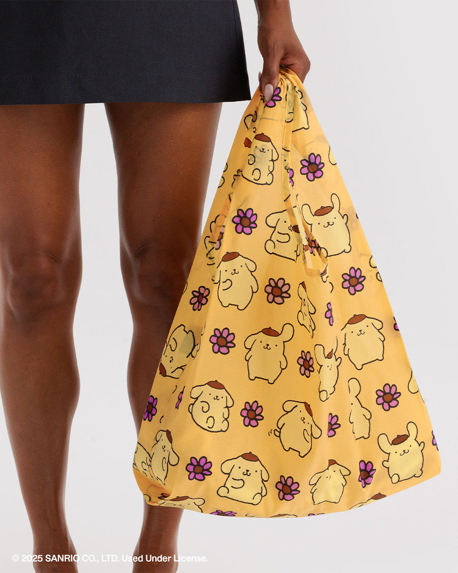 model holding golden yellow standard baggu with pompompurin and pink flower print