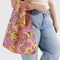 model carrying yellow standard baggu with pink rose print
