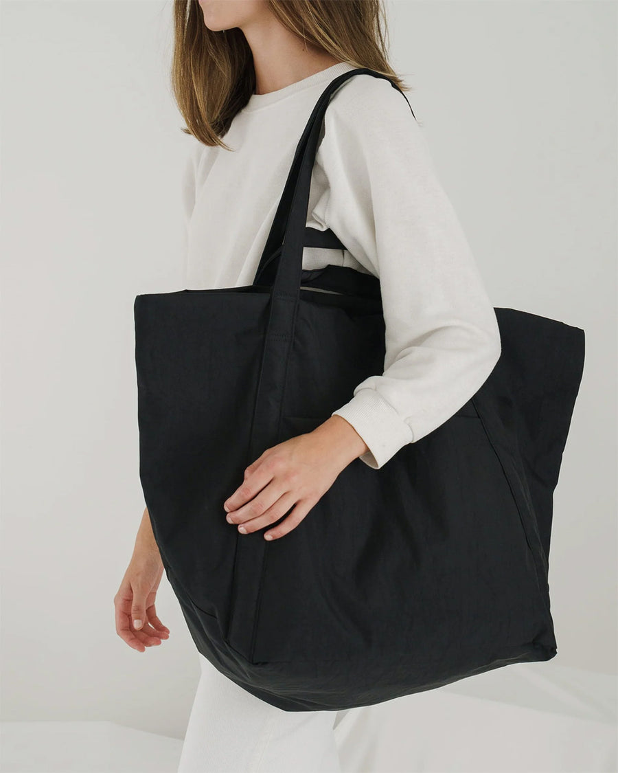 model wearing black large travel cloud bag